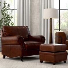 a brown leather chair and ottoman in a living room