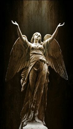 an angel statue with its wings spread out in front of a dark background and light coming from the ceiling