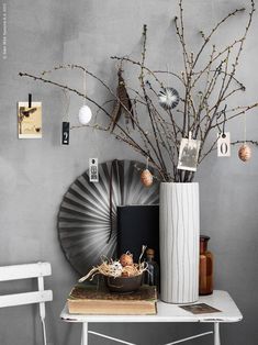 a white table topped with a vase filled with flowers next to a wall mounted mirror