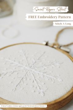 an embroidered snowflake is shown on a white tablecloth with the text free embroidery pattern