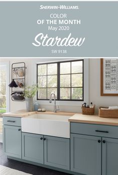 a kitchen with blue cabinets and a white sink in front of a window that reads, she