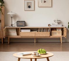 a living room filled with furniture and a coffee table in front of a wall mounted tv