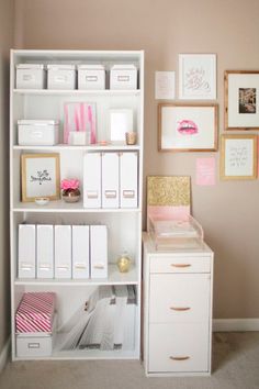 a white book shelf filled with lots of boxes and drawers next to a wall covered in pictures