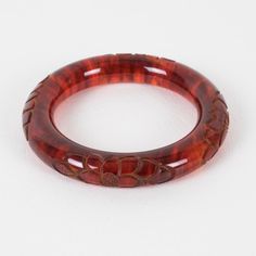 This is part of Chairish’s Costume Jewelry assortment.  Stunning red tea amber marble Bakelite bracelet bangle. Chunky rounded domed shape with a deep floral carving all around. Intense orange-red color with lots of cloudy swirling and translucency. Measurements: Inside across is 2.50 in diameter (6.4 cm) - outside across is 3.63 in diameter (9.2 cm) - width is 0.57 in wide (1.4 cm) - the wall is 0.57 in thick (1.4 cm).  Please see the measurements noted above in the description for the best app Elegant Tortoiseshell Bangle Jewelry, Handmade Bakelite Bangle Bracelet, Vintage Red Round Bangle, Luxury Red Bangle, Handmade Round Bakelite Jewelry, Elegant Bakelite Bracelet Jewelry, Elegant Bakelite Bangle As Gift, Elegant Bakelite Bracelet, Elegant Bakelite Bangle As A Gift