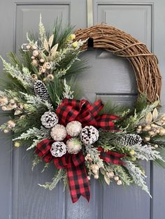 a christmas wreath with pine cones and berries