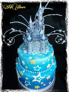 a blue cake with a castle on top and stars all over the icing around it