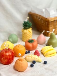 various fruits and vegetables are arranged on a white cloth with a basket in the background