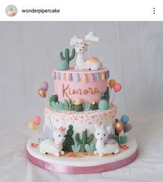 a three tiered cake decorated with llamas, cactuses and other decorations