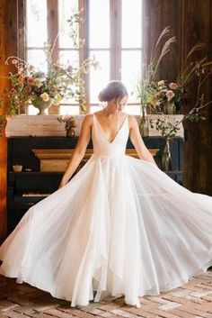 a woman standing in front of a piano wearing a white dress and holding her hands on the side