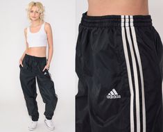 "Vintage 00s track pants by Adidas in black with white stripes and an elastic waist. Baggy tapered fit with zippers at the ankles. Please see measurements and condition below. Every garment we sell is authentic vintage! You will receive the exact item photographed. Condition: Very good vintage with light general wear. Best fits women's: Labelled Medium Tag: Adidas Material:  Nylon MEASUREMENTS Taken from seam to seam while the garment is lying flat. Double the armpit, waist, and hips For referen Swishy Pants, Running Track, Adidas Track Pants, Track Suit, Adidas Track, Athletic Sports, Y2k Black, Black Stripes