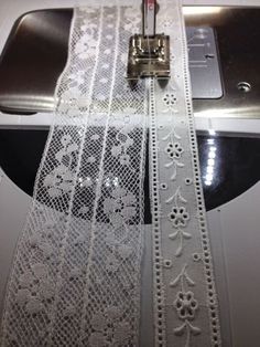 a piece of white lace with a sewing machine on it