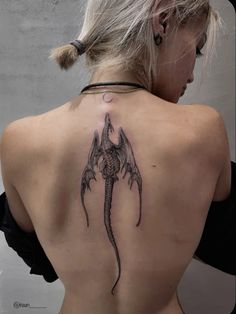 a woman with a dragon tattoo on her back