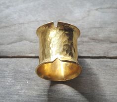 This is a handmade ring made from a bronze sheet then soldered and hammered and finally gold plated 24ct MATERIALS: gold plated bronze DIMENSION:2 cm height(0,8 inch approximately) I can make this ring to your size.You can find your size by looking here:http://www.bluenile.com/pdf/bluenile_ringsizer_copyright2008.pdf Every ring is handmade and unique. You will receive a very similar to the photo but not identical. I will pack your ring in a gift box as in my last photo.See my shop policies here: Artisan Gold Ring With Hammered Detail, Artisan Gold Hammered Rings, Artisan Hammered Gold Rings, Unique Gold Hammered Wide Band Ring, Unique Hammered Gold Wide Band Ring, Hand Forged Gold Wide Band Ring, Hand Forged Gold Wide Band Ring Gift, Architectural Rings, Big Statement Rings