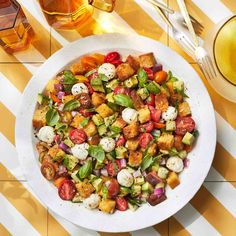 a white bowl filled with lots of food on top of a yellow and white table