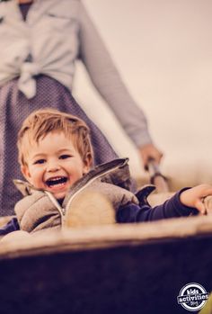 a little boy sitting on top of a wooden bench