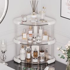 a round shelf filled with lots of different types of perfumes and candles on top of a table