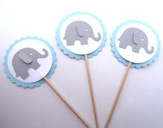 three cupcake toppers with elephants on them sitting next to each other in front of a white background