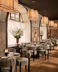 a restaurant with tables, chairs and chandeliers