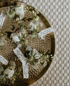 flowers are placed on top of each other in a metal tray with name tags attached to them