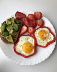 an egg, avocado and strawberries are on a paper plate with toast