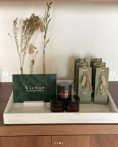 various items are displayed on a counter in front of a white wall and wooden cabinets