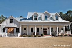 a large white house sitting on top of a dry grass field