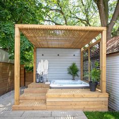 a hot tub sitting under a wooden pergol