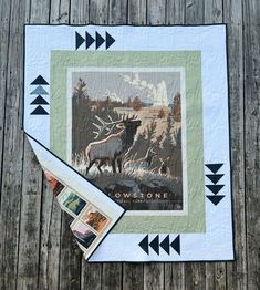 a quilt with an image of a moose on it next to a pair of scissors