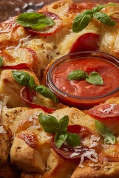 a pizza with tomato sauce and basil leaves on top