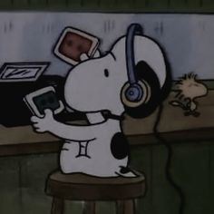 a cartoon dog with headphones on sitting at a desk and holding a cell phone