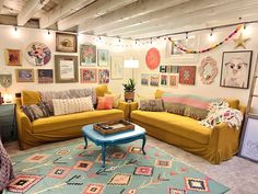 a living room filled with yellow couches and colorful rugs on top of carpeted flooring