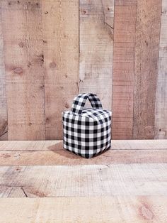 a black and white checkered bag sitting on top of a wooden table next to a wall