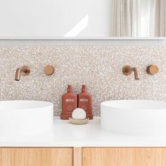 two white sinks sitting next to each other on top of a counter