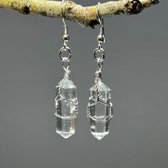 Clear Quartz Crystal Dangle Earrings, Quartz Gemstone Wire Wrapped Earrings  You will receive 1 (ONE) Pair of Clear Quartz Dangle Earrings like the item pictured.   Item description Stone: Clear Quartz  Finish: Polished, wire wrapped Drop length: 50mm Length: 30mm Width: 10mm These raw crystal earrings celebrate the natural beauty of clear quartz jewelry. The translucent beauty of quartz crystal captures the light and adds a touch of elegance to any outfit. Handmade with care, these gemstone ear Clear Quartz Earrings, Astrology Outfits, Clear Quartz Jewelry, Raw Crystal Earrings, Crystal Quartz Earrings, Quartz Crystal Jewelry, Dark Crystal, Wrapped Earrings, Tourmaline Pendant