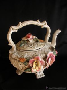 an ornate teapot with flowers on it