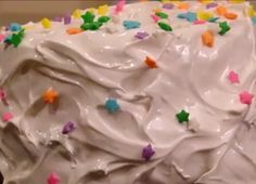 a cake with white frosting and colorful stars on it