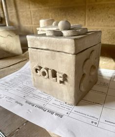 a clay box sitting on top of a piece of paper