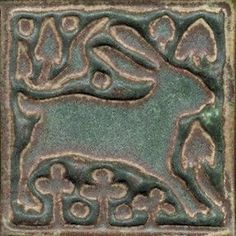 an intricately designed tile in the shape of a dog's head and tail