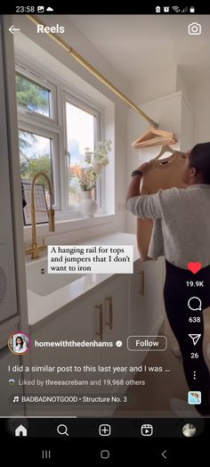 a woman is holding up a cardboard box in the kitchen