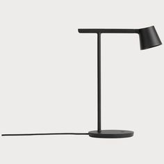 a black lamp on a white background with a cord attached to the base and one light plugged in