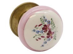 a pink and white cabinet door knob with flowers painted on it