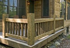 a wooden porch with rocking chairs on the front and side of it, in front of a log cabin