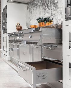 an industrial style kitchen with stainless steel appliances and drawers on both sides, along with marble flooring