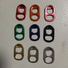 six different colored metal buckles on a white surface