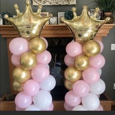 two large balloons with gold crowns on top are in front of a fireplace mantel