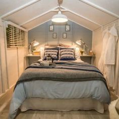 a bed sitting in the middle of a bedroom next to a window with shutters