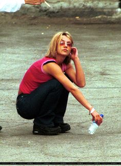 a woman sitting on the ground holding a water bottle