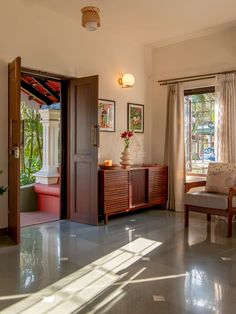 a living room filled with furniture next to a large open door on the side of a wall