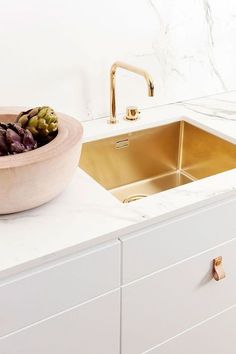 a kitchen sink with a bowl of flowers on the counter