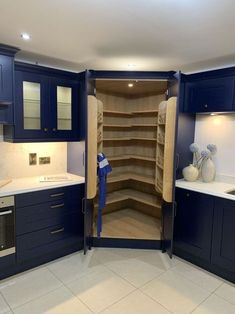 an empty kitchen with blue cabinets and white counter tops is seen in this image from the inside